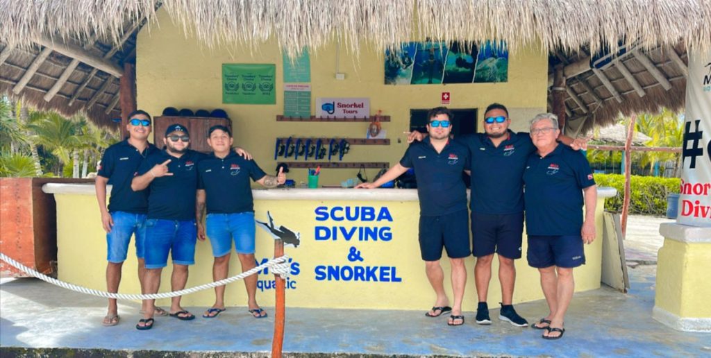 Dive crew in front of a scuba diving and snorkel shop in Cozumel