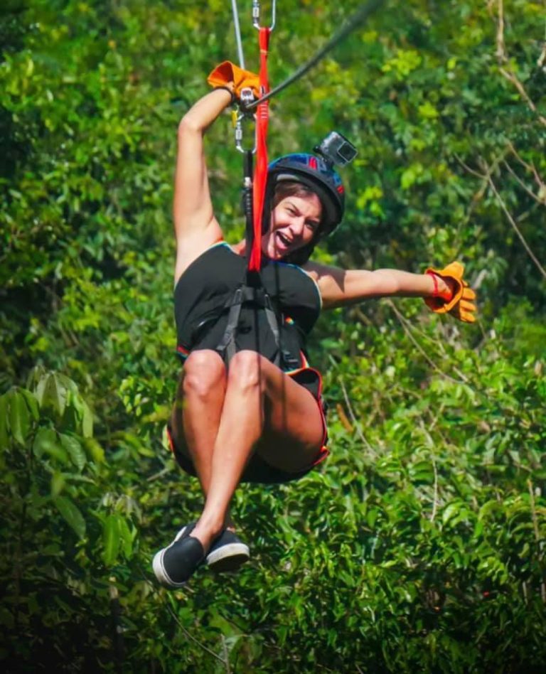 Guest smiling on a zip line in the jungle
