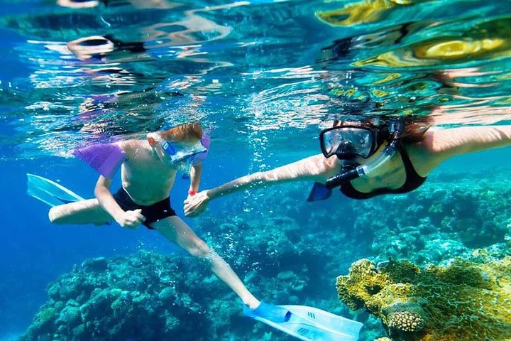 Two snorkelers swimming over a colorful reef