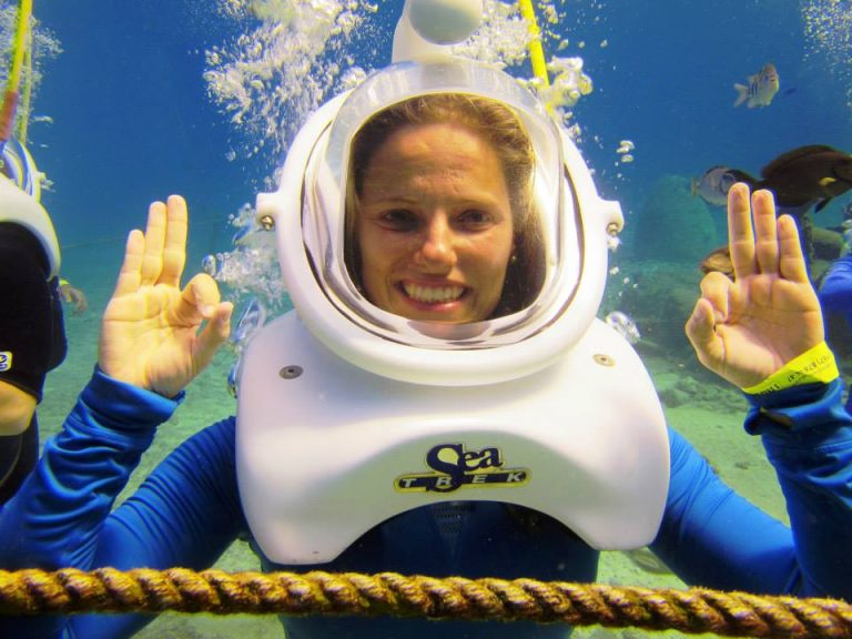 Smiling guest wearing a Sea Trek helmet underwater